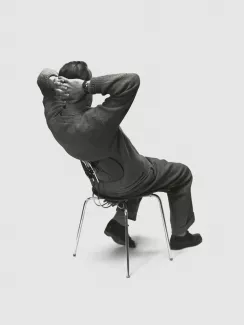 Egon Eiermann sitting on a chair he designed for Wilde+Spieth